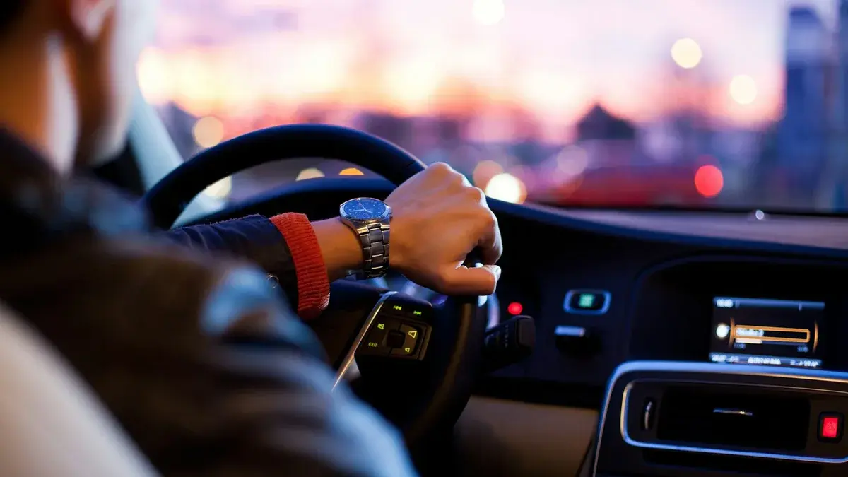Élégante berline VTC noire en circulation fluide sur une grande avenue urbaine